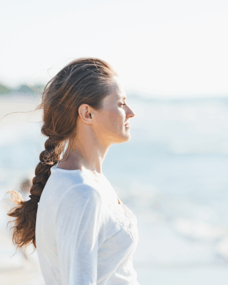 Kvinna som tittar ut mot havet. Symbol för Sorgbearbetning med Julija Kondovska